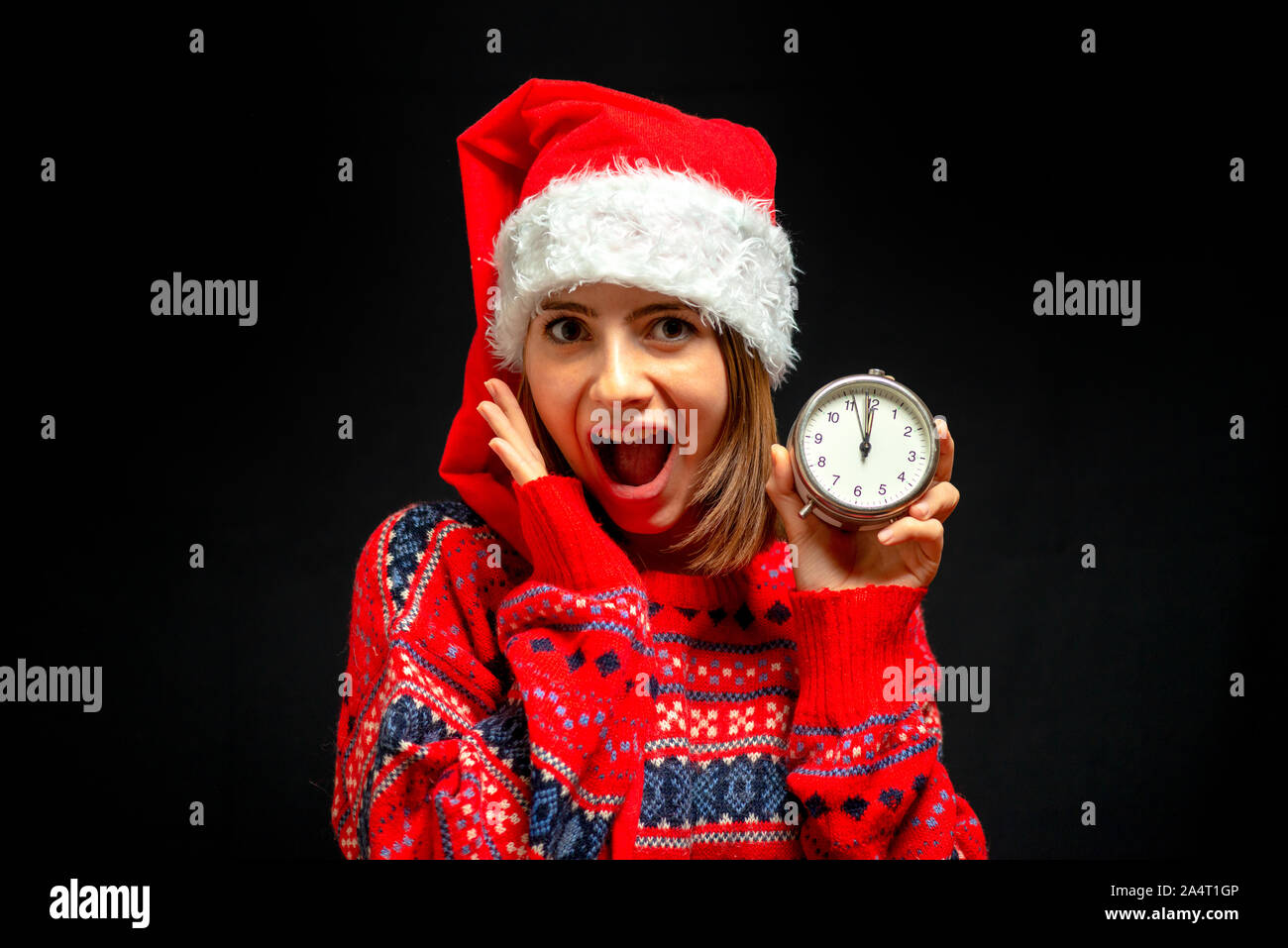 Fille en robe de Noël avec réveil dans sa main Banque D'Images