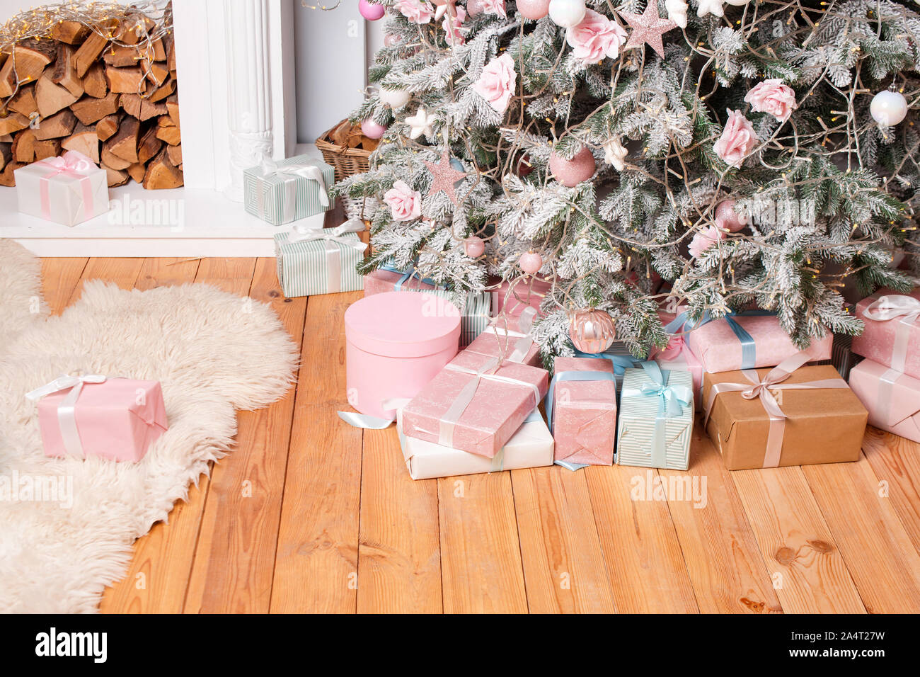 De beaux cadeaux de Noël sur le plancher près de sapin dans la salle avec cheminée. Des cadeaux de Noël et de décoration. Heureux Vacances d'hiver Banque D'Images