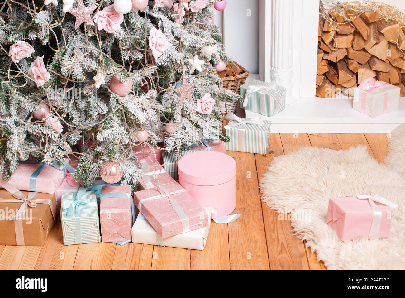 De beaux cadeaux de Noël sur le plancher près de sapin dans la salle avec cheminée. Des cadeaux de Noël et de décoration. Heureux Vacances d'hiver Banque D'Images