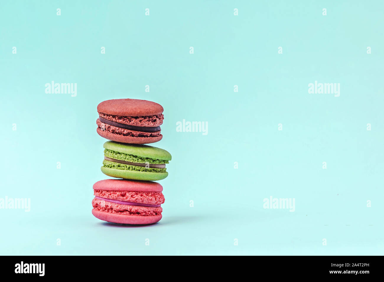 Assortiment de macarons colorés sur fond vert menthe avec copie espace. Banque D'Images