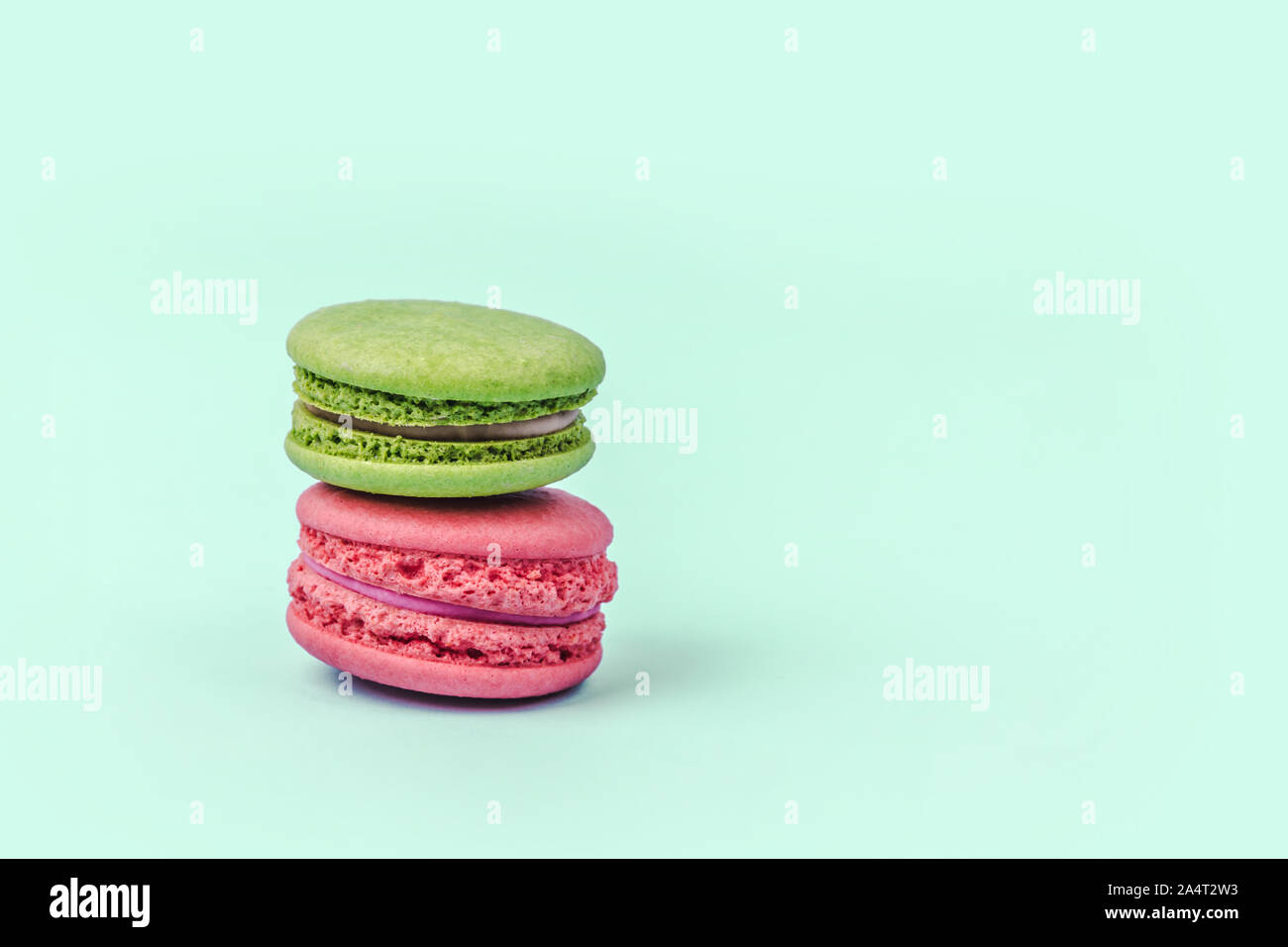 Assortiment de macarons colorés sur fond vert menthe avec copie espace. Banque D'Images