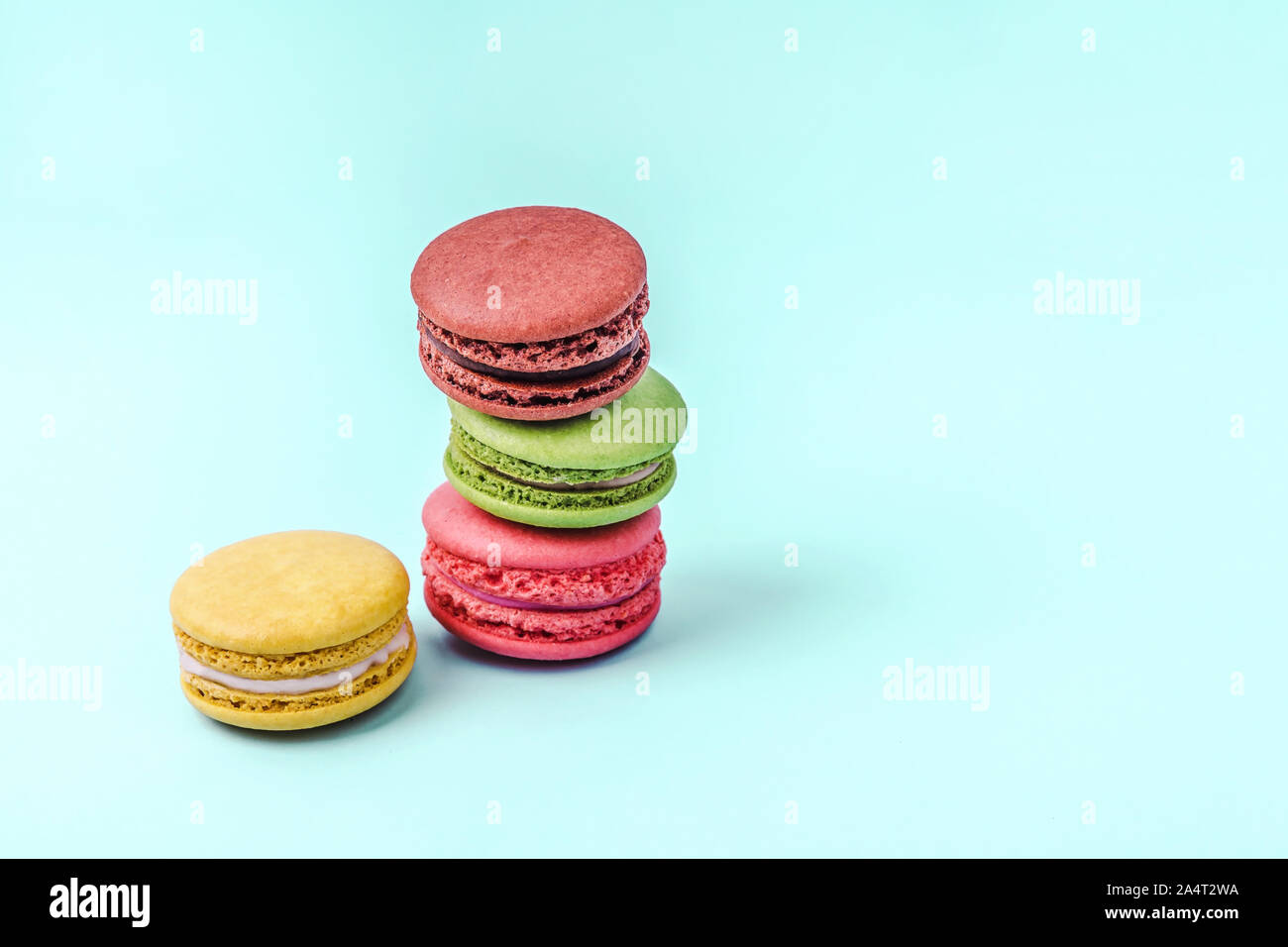 Assortiment de macarons colorés sur fond vert menthe avec copie espace. Banque D'Images