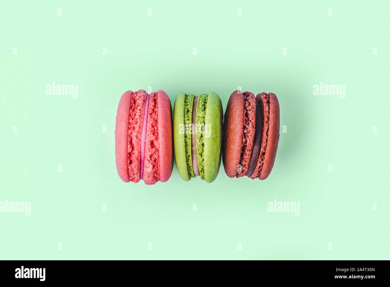 Assortiment de macarons colorés sur fond vert menthe avec copie espace. Banque D'Images