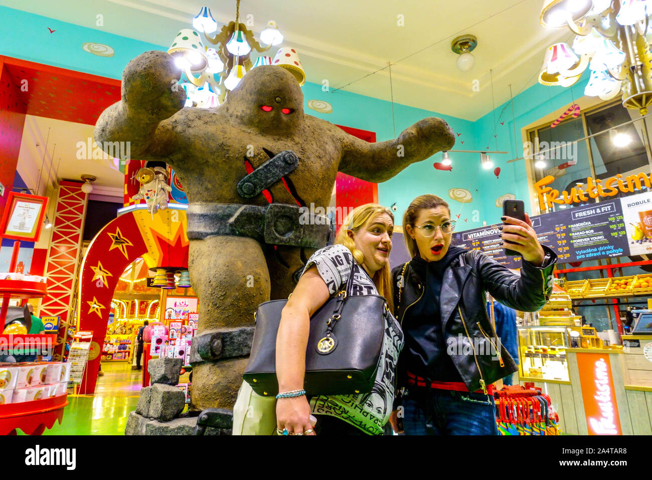 Les femmes prenant le Golem de Prague Prague selfies Hamley's toy shop, magasin à l'intérieur de République Tchèque Banque D'Images