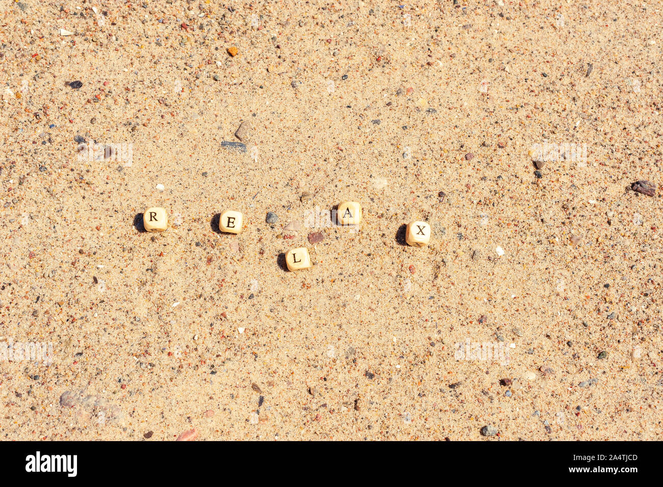Des lettres sur les cubes en bois sont repliées dans la parole vous détendre sur le sable Banque D'Images