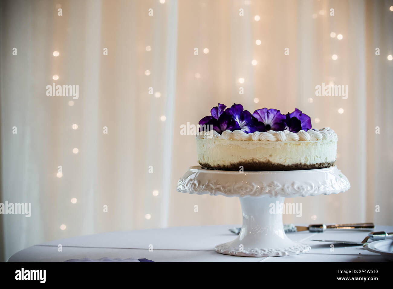 Les non-traditionnel gâteau de mariage, gâteau au fromage avec des fleurs violet sur blanc Banque D'Images