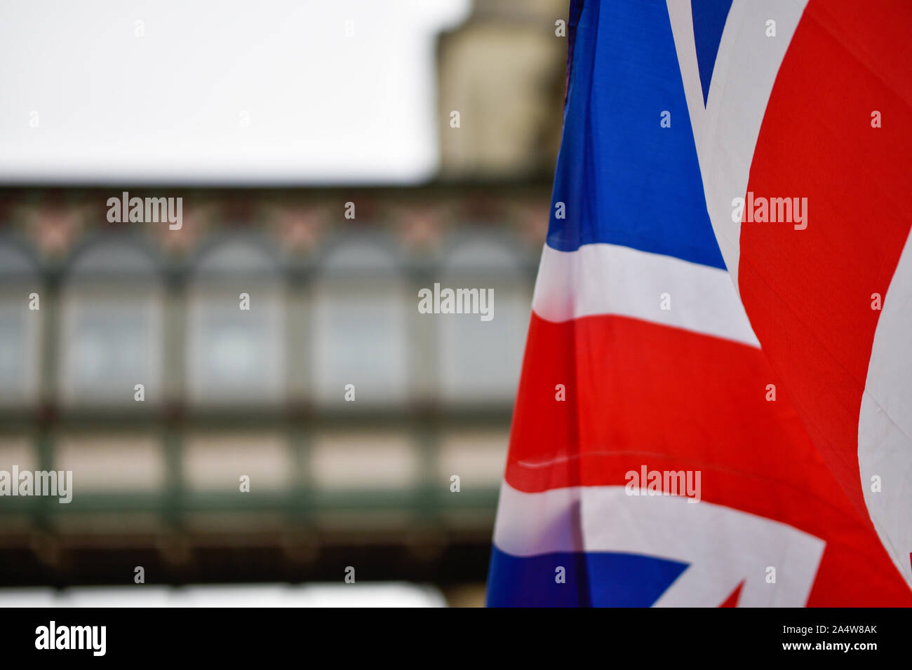 Drapeau britannique dans l'avant-plan sur une rue de Londres, un bâtiment vu de plus en plus floue dans l'arrière-plan, fournissant copyspace Banque D'Images