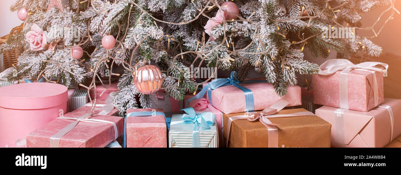 De beaux cadeaux de Noël sur le plancher près de sapin dans la salle. Des cadeaux de Noël et de décoration. Heureux Vacances d'hiver Banque D'Images
