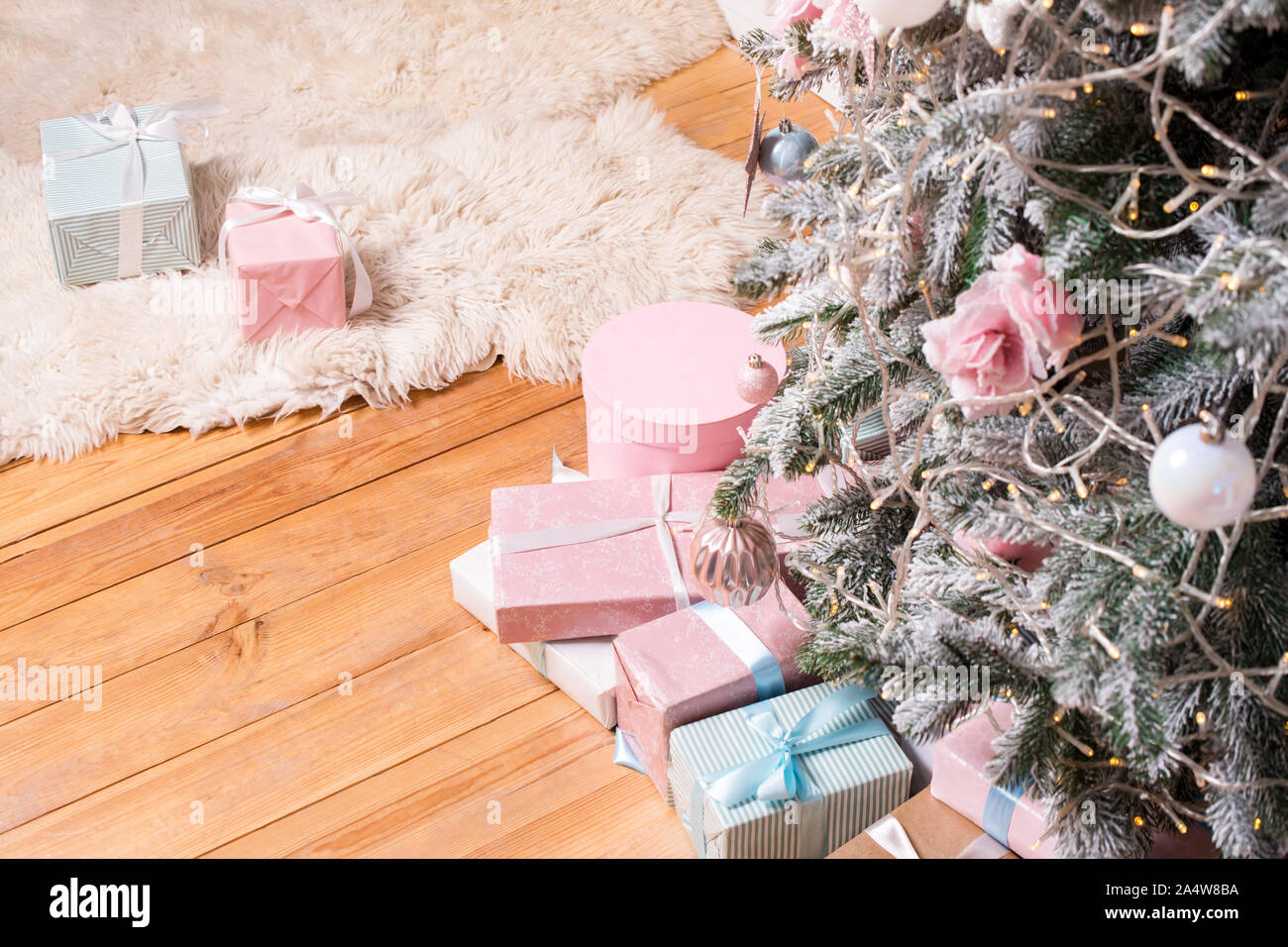 De beaux cadeaux de Noël sur le plancher près de sapin dans la salle. Des cadeaux de Noël et de décoration. Heureux Vacances d'hiver Banque D'Images