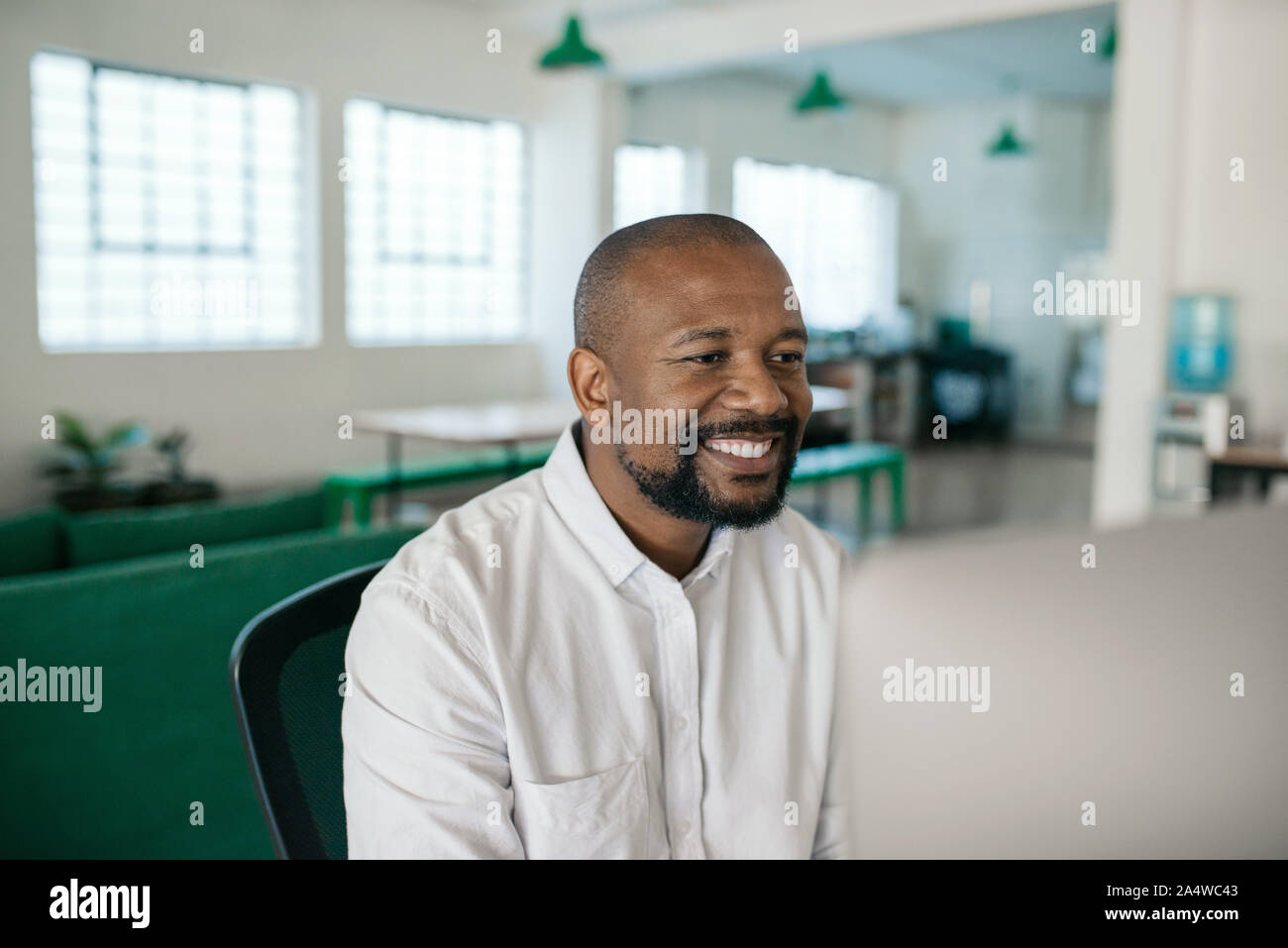 Smiling African American businessman à l'aide d'un ordinateur dans un bureau Banque D'Images