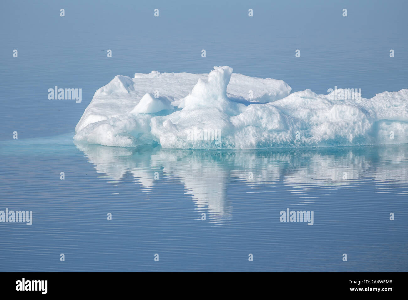 Belle réflexion avec iceberg flottant dans la mer calme off Svalbard dans l'Arctique Banque D'Images