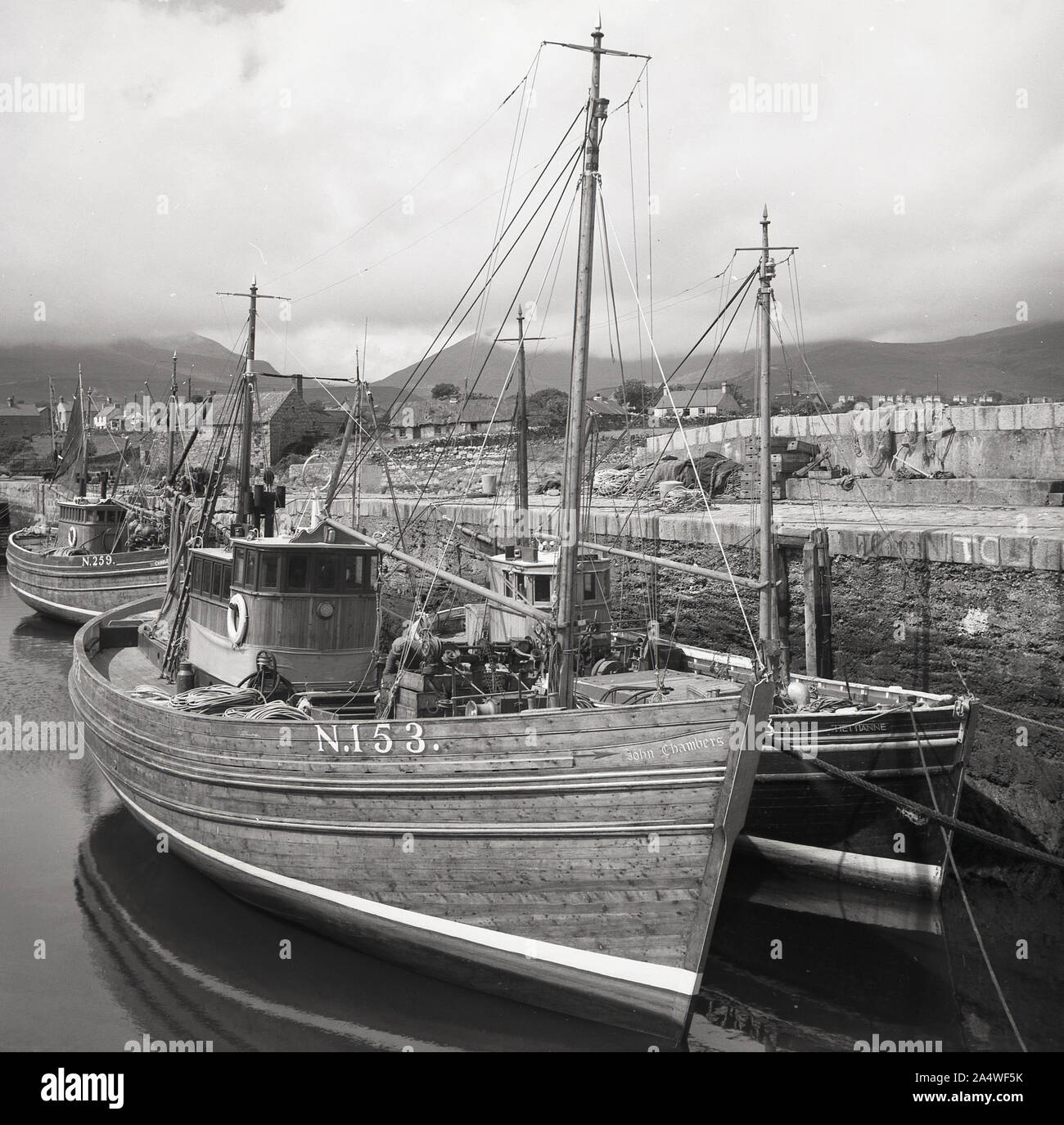 Années 1950, historiques, sur la côte d'Antrim, de vieux bateaux de pêche en bois amarré dans un port, N. 259 et N. 153, l'Irlande du Nord. Banque D'Images