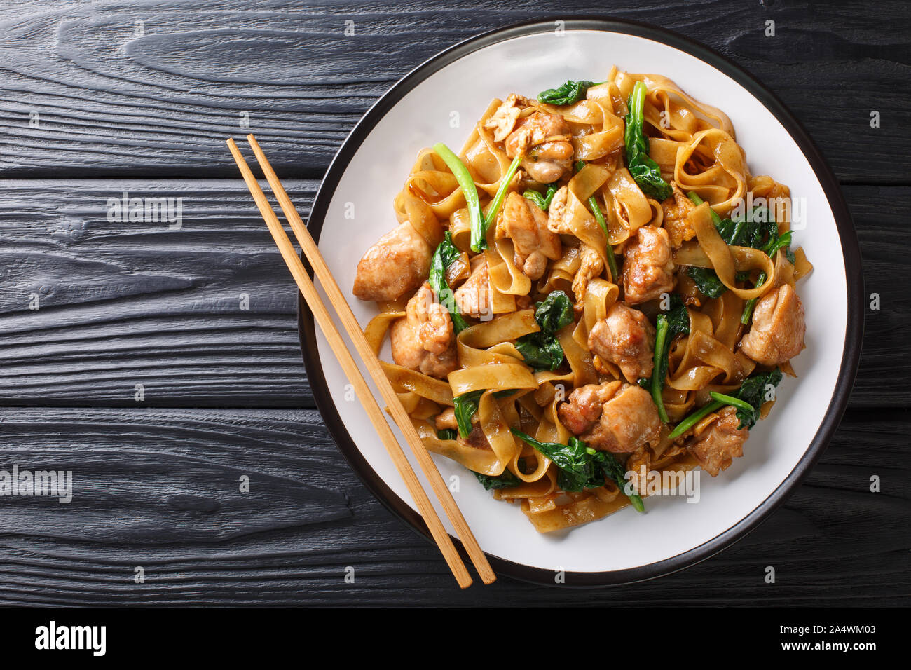 Les sautés de nouilles au poulet, brocoli chinois et l'oeuf sur une assiette sur la table. Voir Pad Thaï ew. Haut horizontale Vue de dessus Banque D'Images