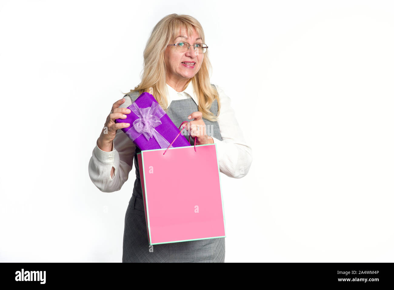 Hauts femme avec un paquet rose et un cadeau dans une boîte de violette, sur un fond blanc. Les achats de Noël. Banque D'Images