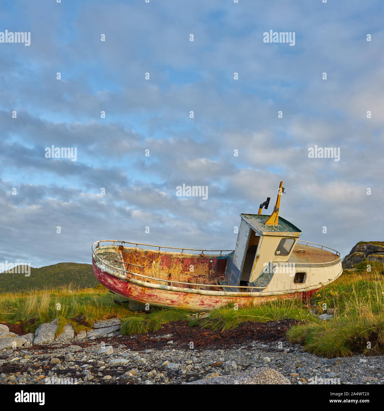 Un bateau abandonné sur la plage. Les nuages ressemblent à des vagues. Un moment impressionnant. Banque D'Images