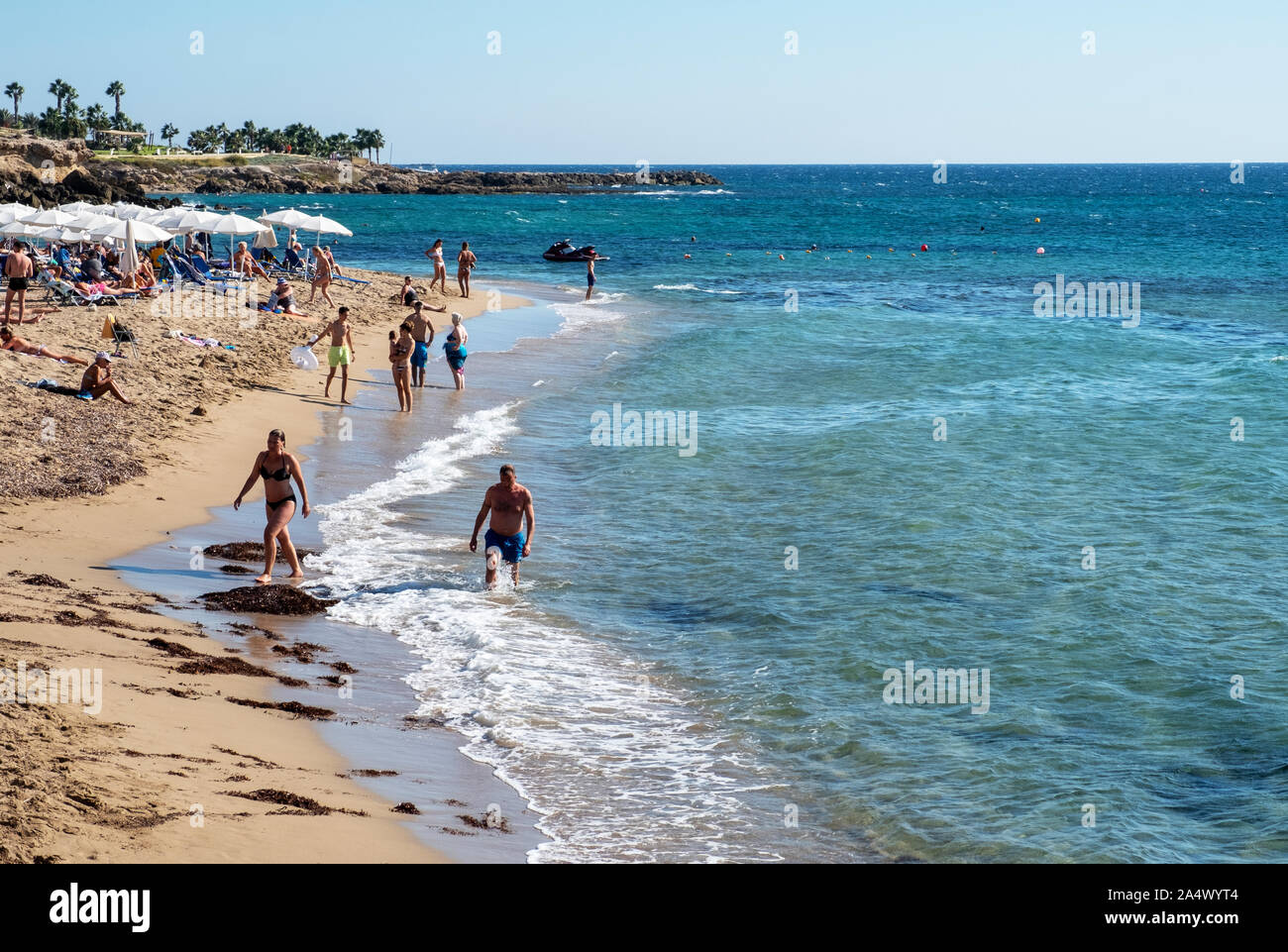 Les vacanciers sur une plage de sable fin dans le centre touristique de Paphos, Chypre. Banque D'Images