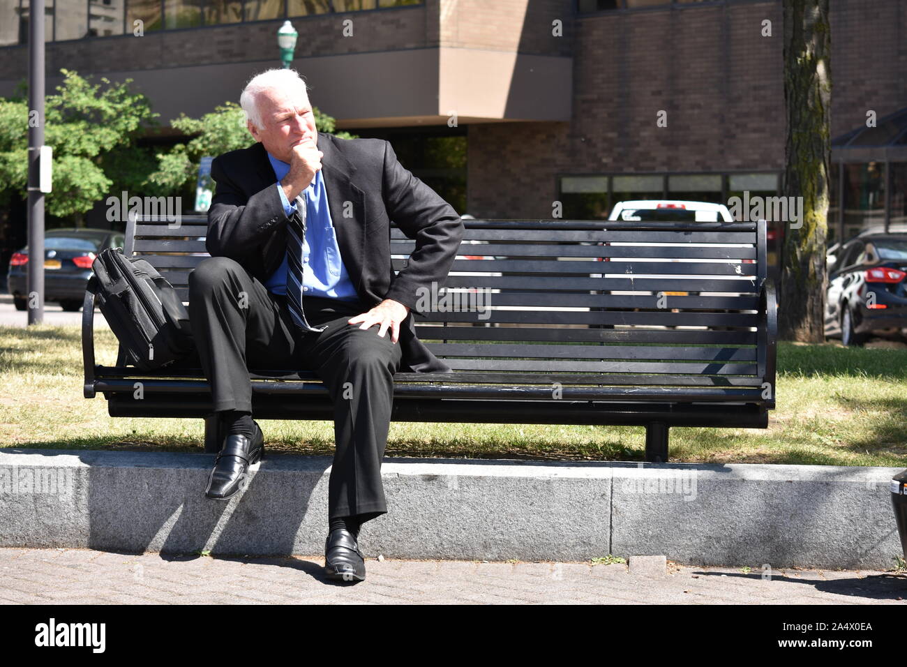 L'homme d'affaires adultes de prendre une décision assis sur un banc Banque D'Images