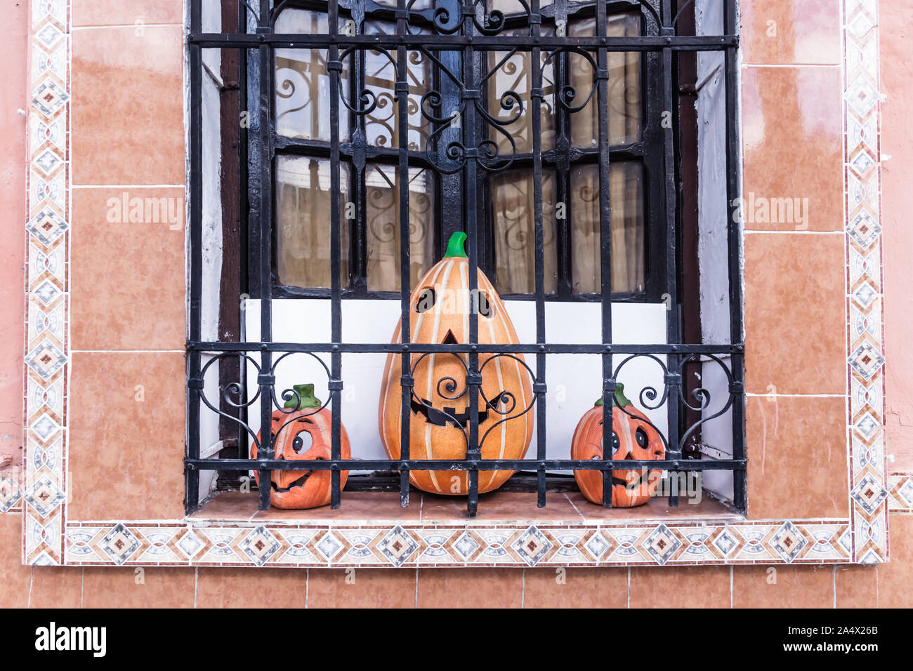 Sourire trois citrouilles dans une fenêtre coloniale de carrelage traditionnel, Merida, Mexique Banque D'Images
