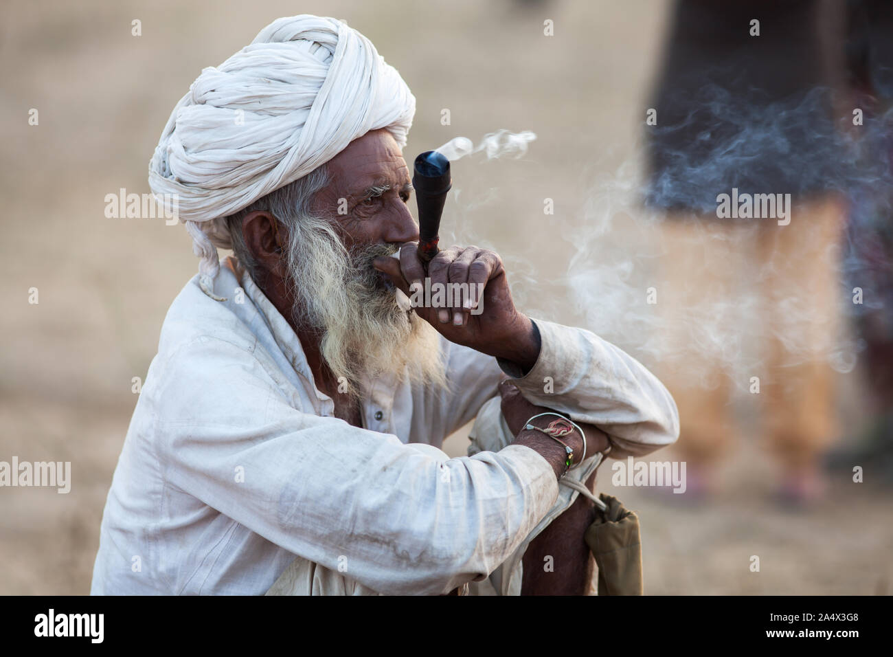 Man smoking a Rajasthani chillum (tuyau) de haschich à Pushkar Camel Fair, Rajasthan, Inde Banque D'Images