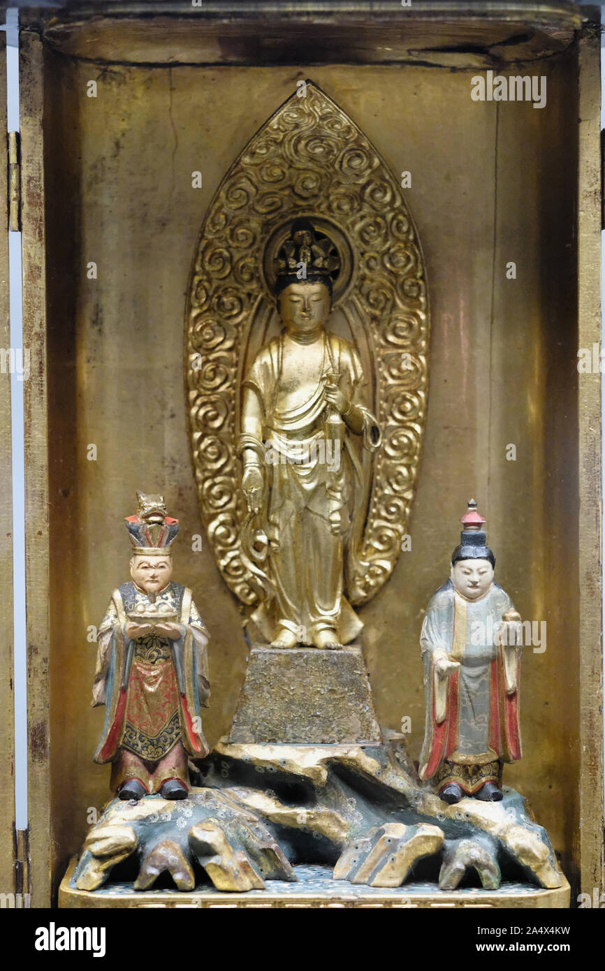 Composition sculpturale oriental religieux dans une boîte de métal représentant une déité et figures de prêtres Banque D'Images