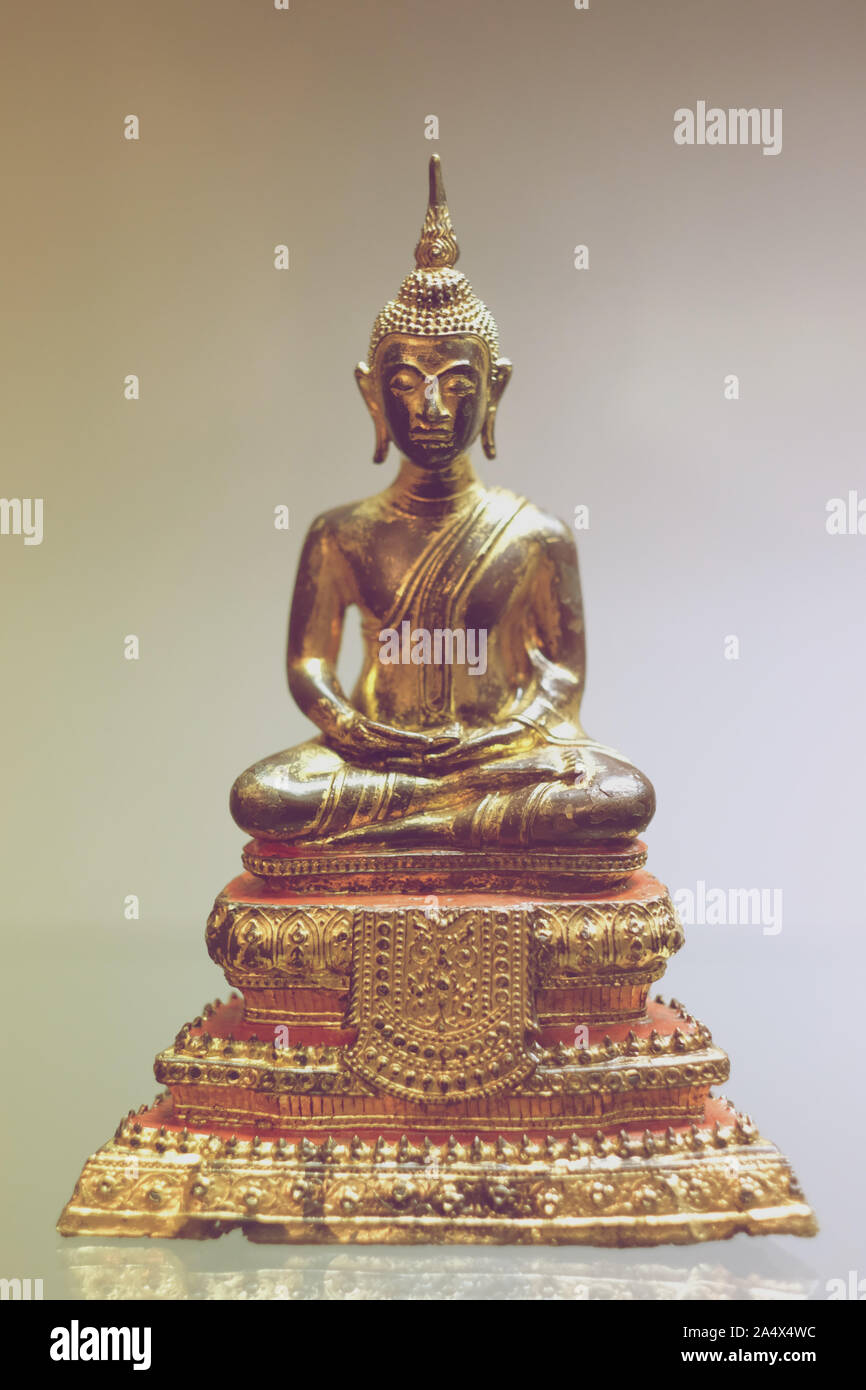Statue de Bouddha en laiton assis dans une posture de méditation sur un piédestal Banque D'Images