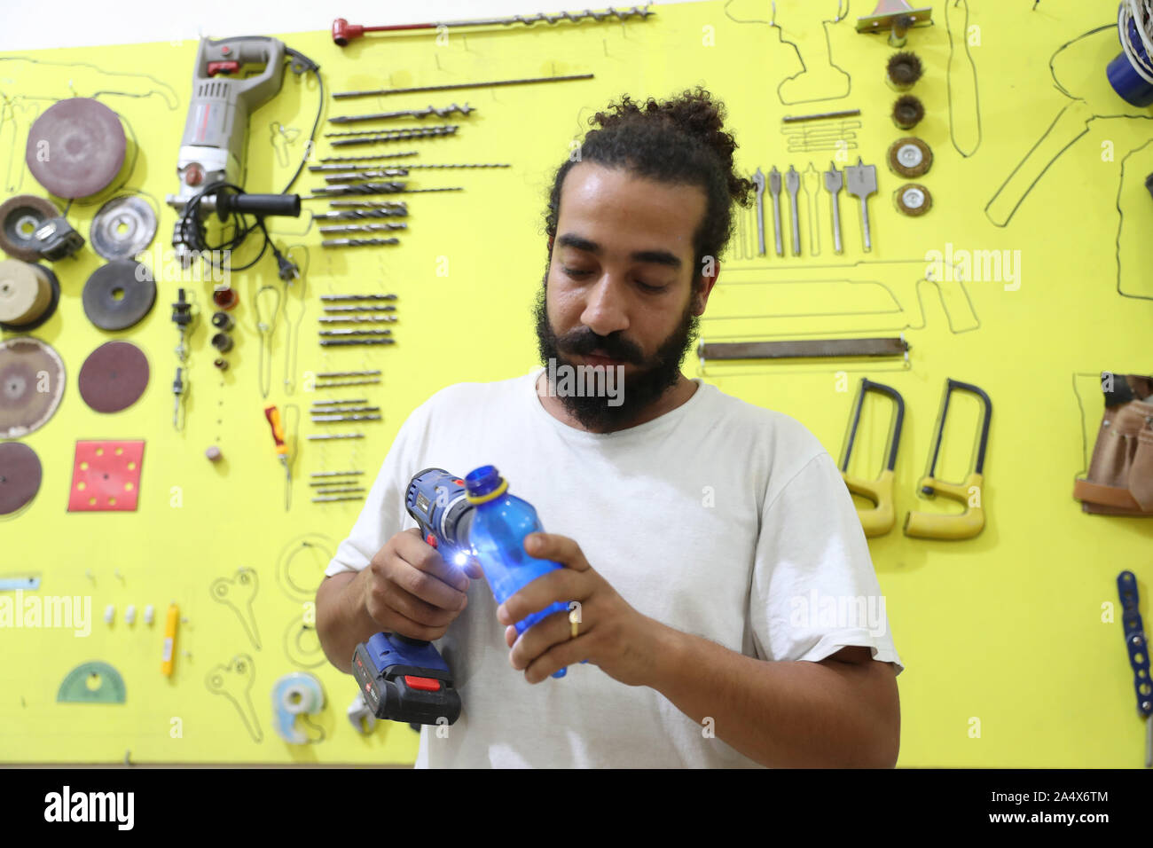 Louxor, Egypte. 16 Oct, 2019. Ombragé Rabab, fondateur de la poubelle Music Band, travaille dans son atelier à Louxor, Égypte, le 11 octobre 2019. Pour aller avec 'caractéristique : artiste égyptien se transforme les déchets en crédit des instruments de musique : Ahmed Gomaa/Xinhua/Alamy Live News Banque D'Images