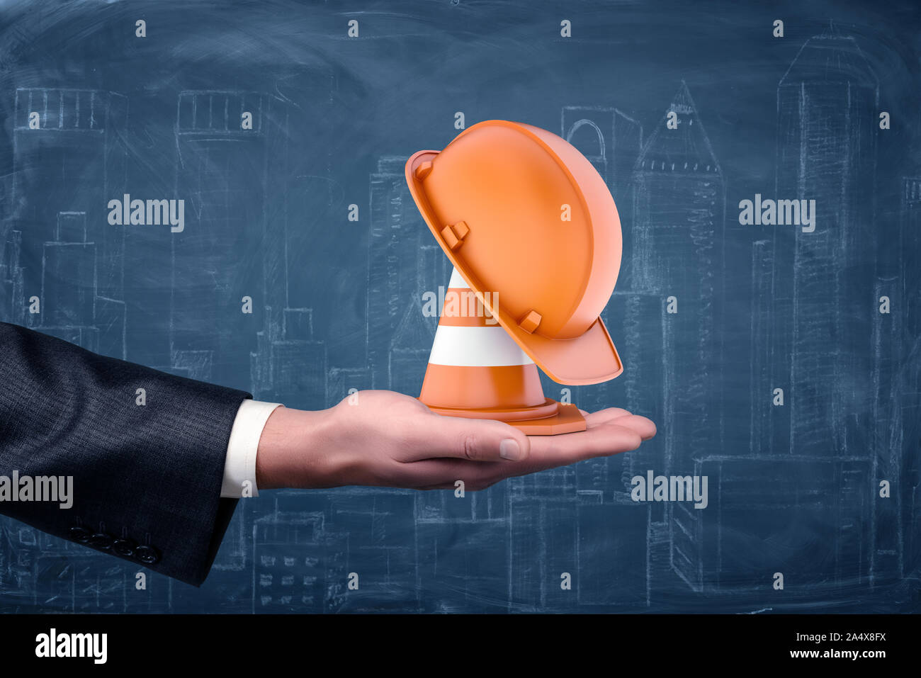 Un trafic à rayures et d'un cône orange de hat standing on businessman's palm. Banque D'Images