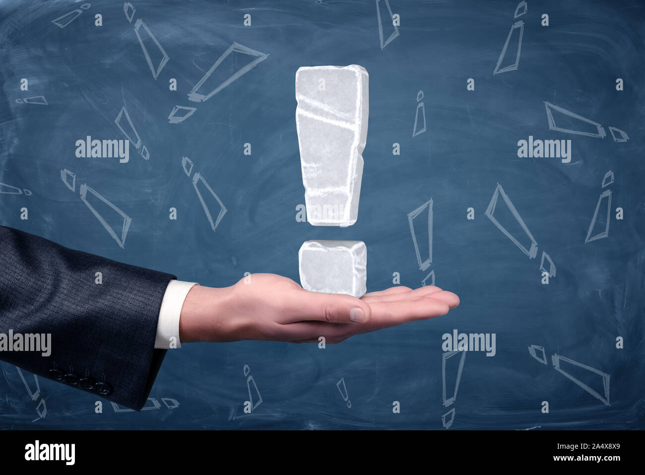 Un point d'exclamation fait de glace blanche placée sur l'homme d'ouvrir Palm sur tableau arrière-plan. Banque D'Images