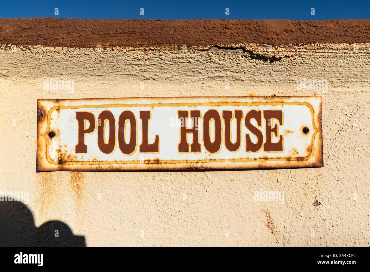 Old rusty pool house signer sur mur en stuc. Banque D'Images