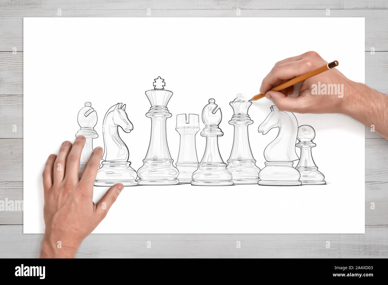 Homme mains Utilisez un crayon pour dessiner un ensemble complet de pièces d'échecs sur papier blanc. Banque D'Images