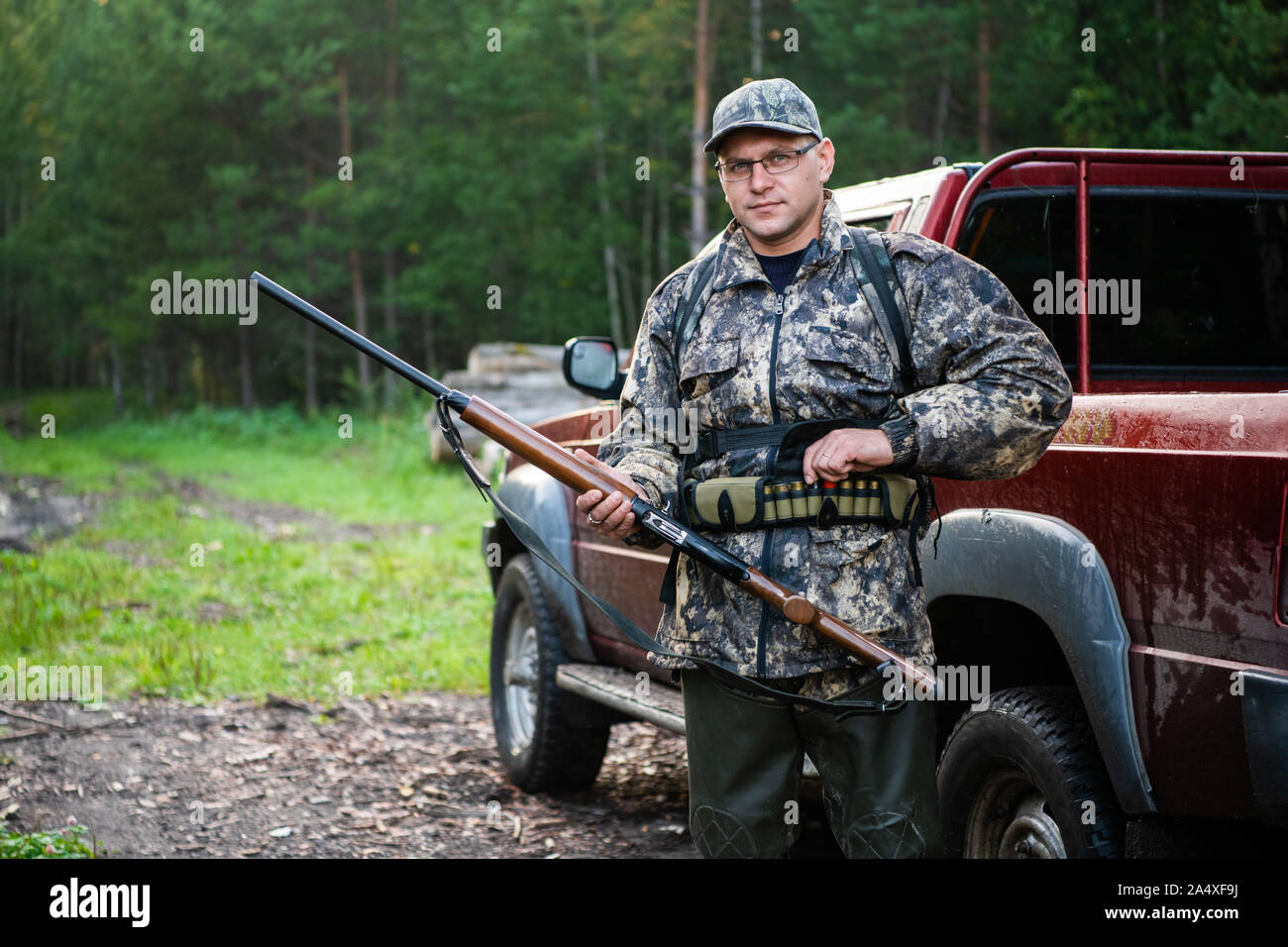 L'homme part à la chasse à la forêt en été. Huntsman avec un fusil de chasse la préparation de cartouches de fusil de chasse avant sa carabine Banque D'Images