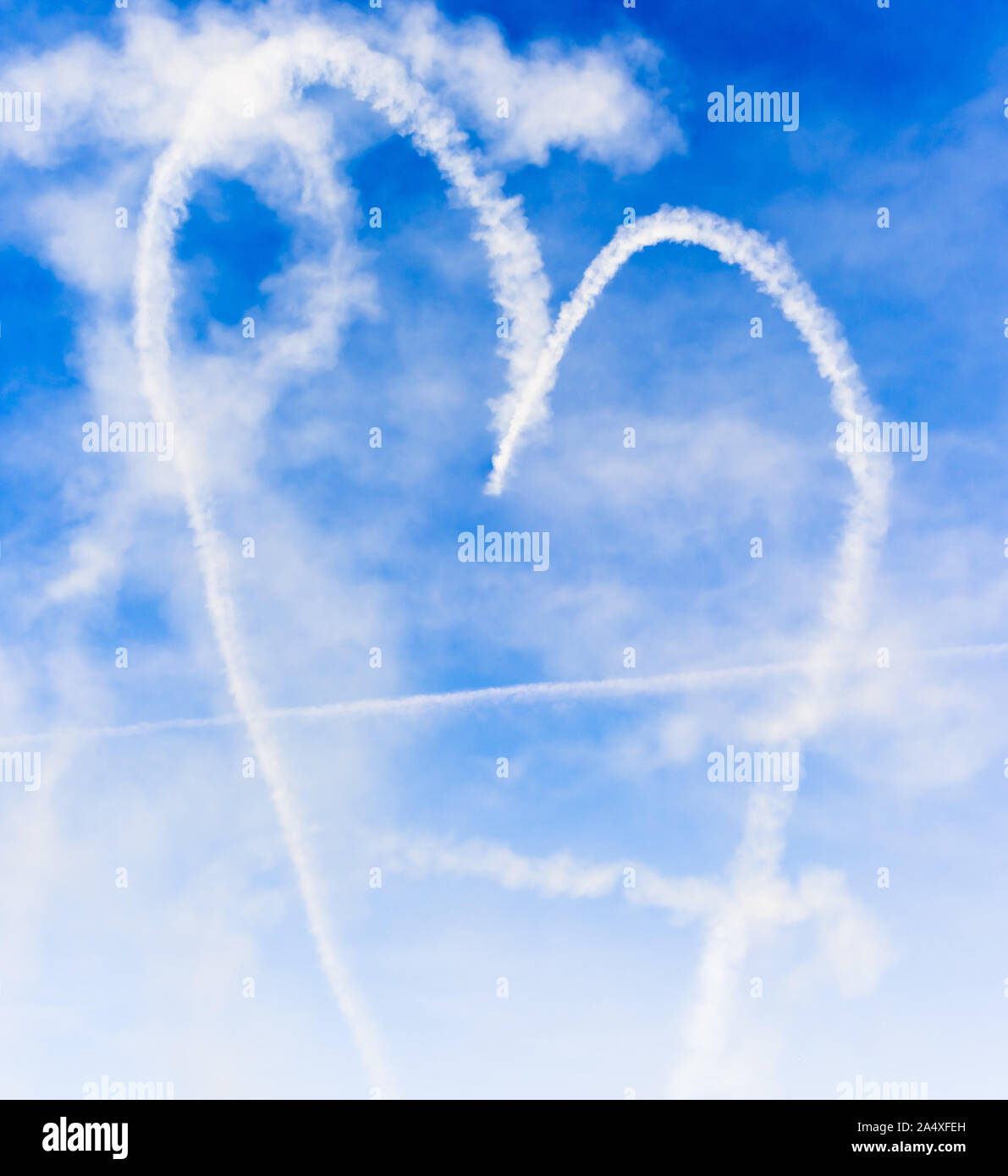 Forme de coeur avec la flèche de Cupidon écrit dans le ciel avec de la fumée Banque D'Images