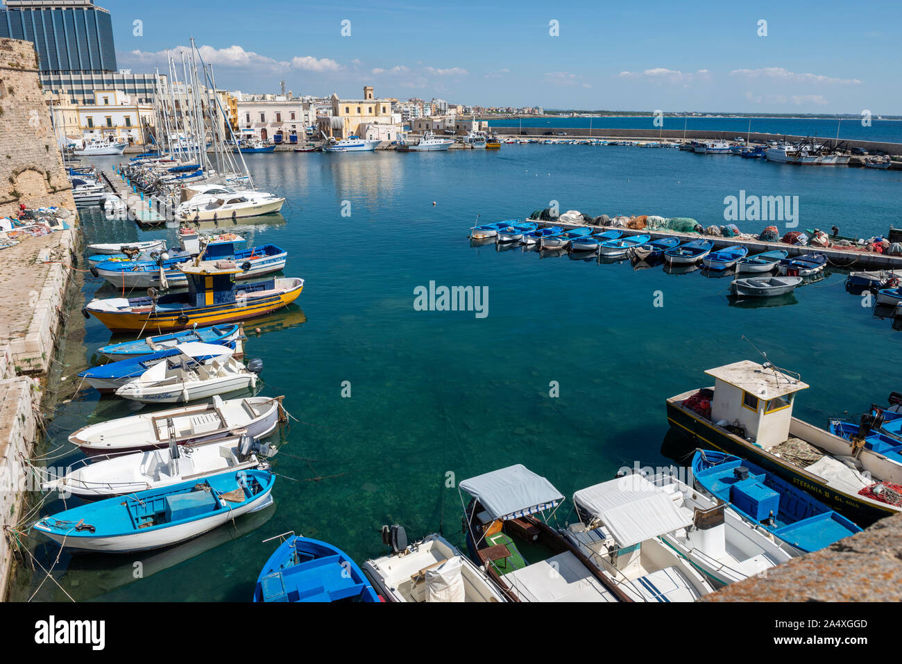 Bateaux amarrés dans le port à côté de l'ancien mur de la ville dans la vieille ville de Gallipoli, Puglia (Pouilles) dans le sud de l'Italie Banque D'Images