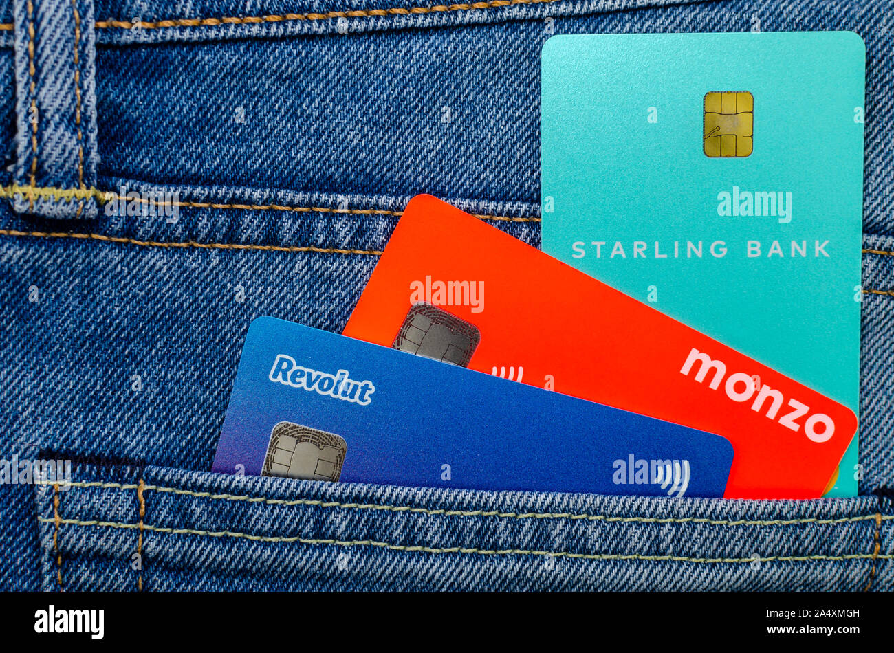 L'Monzo, Revolut Starling et cartes bancaires coller à partir de la même poche de jeans. Concept pour un concours sur l'aileron, tech. Photo mise à plat. Banque D'Images