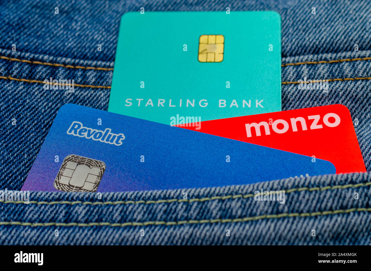 L'Monzo, Revolut Starling et cartes bancaires coller à partir de la même poche de jeans. Concept pour un concours sur l'aileron, tech. Banque D'Images