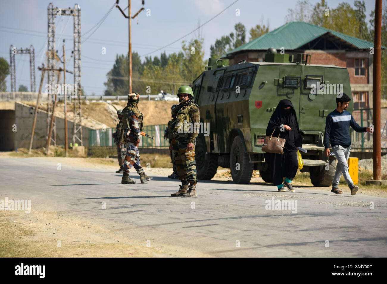 Anathnag, Inde. 16 Oct, 2019. Cachemiris passe devant l'armée indienne-hommes debout près de gunfight alerte dans Bejhbehara site sud, Cachemire quelques 60 km de Srinagar, capitale d'été du Cachemire indien.3 après avoir tué des militants une fusillade a éclaté entre les forces indiennes et militants dans le sud du Cachemire Ananthnag District, à 60 km de la capitale d'été du Jammu-et-Cachemire. Credit : SOPA/Alamy Images Limited Live News Banque D'Images