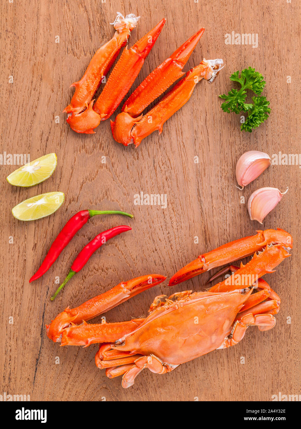 Pinces de crabe bouilli avec de la chaux, le piment, l'ail et persil sur fond de bois. Banque D'Images