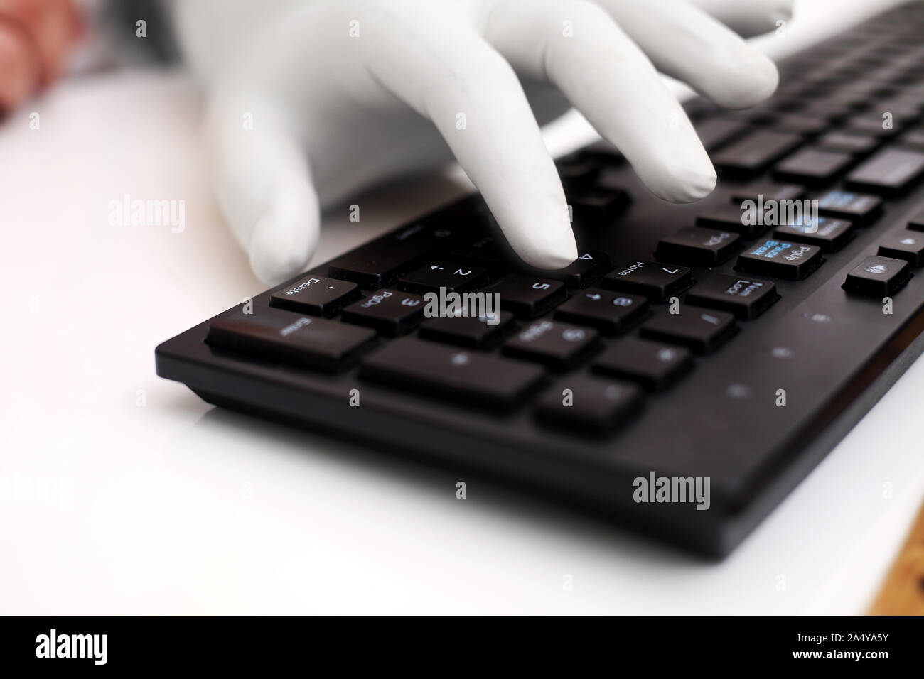 Photo de l'homme entrant avec clavier et le port de gants à la main. Isolé sur fond blanc. Banque D'Images