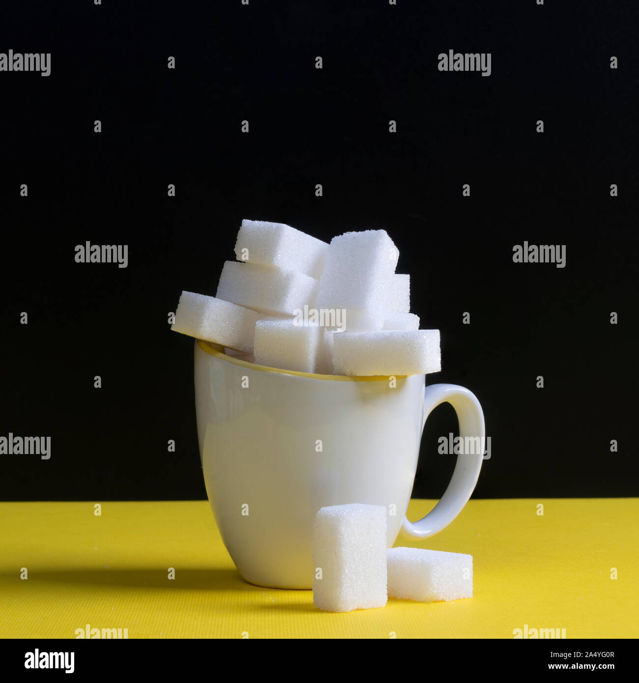 Quelques morceaux de sucre dans une tasse blanche Banque D'Images