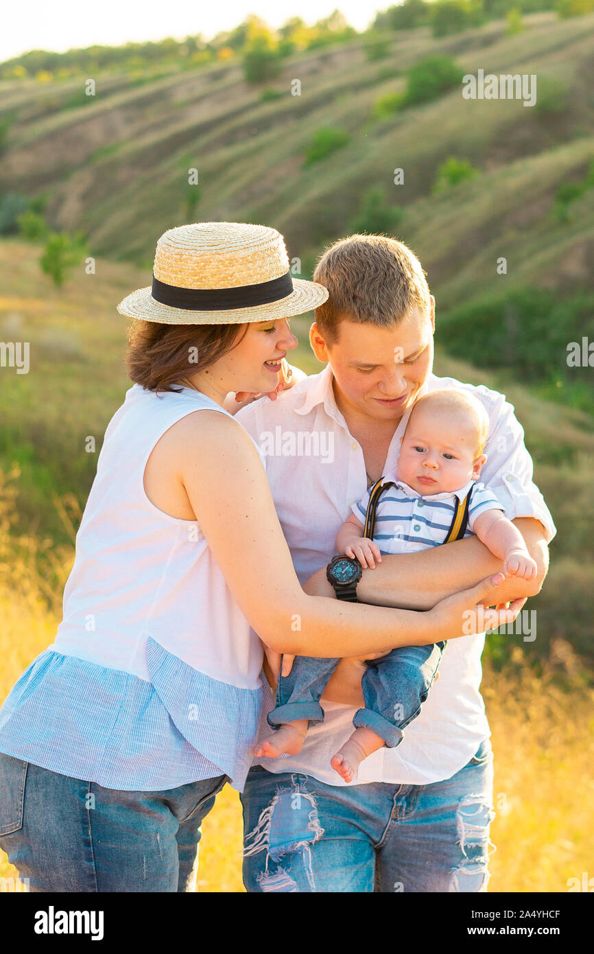 Famille avec bébé d'été à coucher du soleil. Banque D'Images