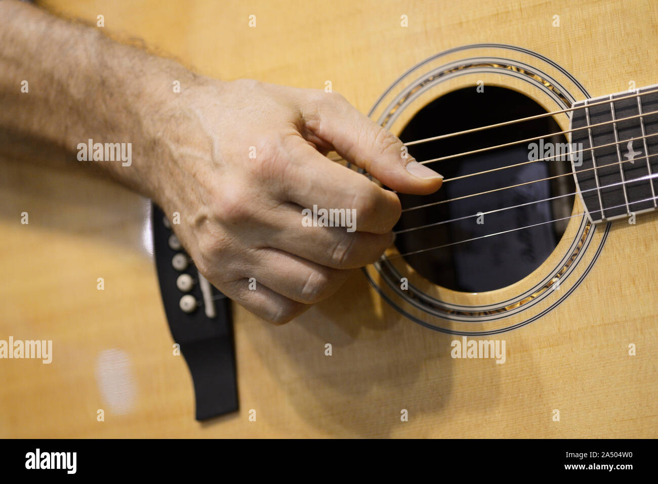 Gros plan de la main d'un musicien jouant de la guitare acoustique Banque D'Images