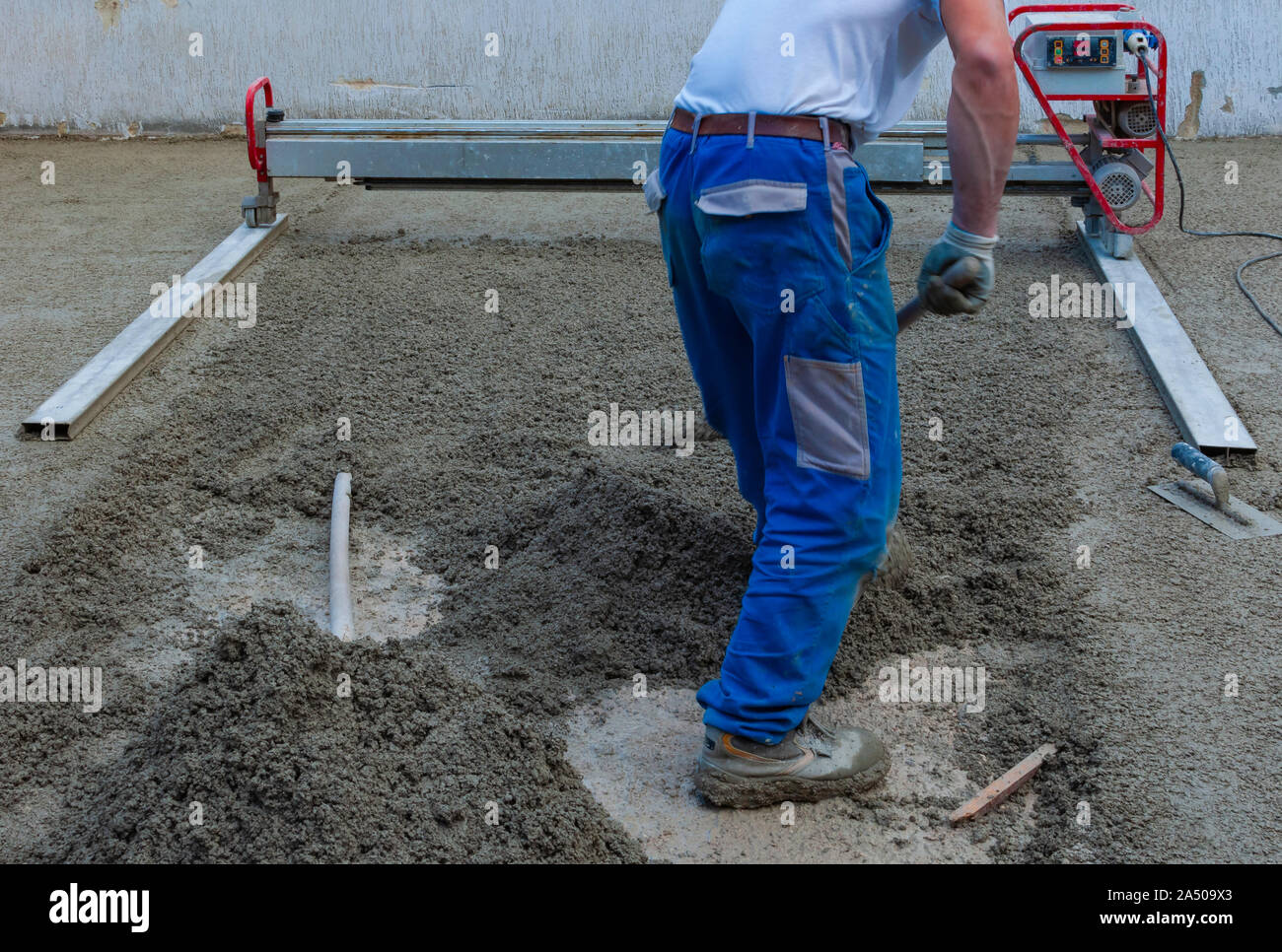 Le travailleur d'un laser screed mise à niveau de la machine de béton coulé d'une surface sur un site de construction Banque D'Images