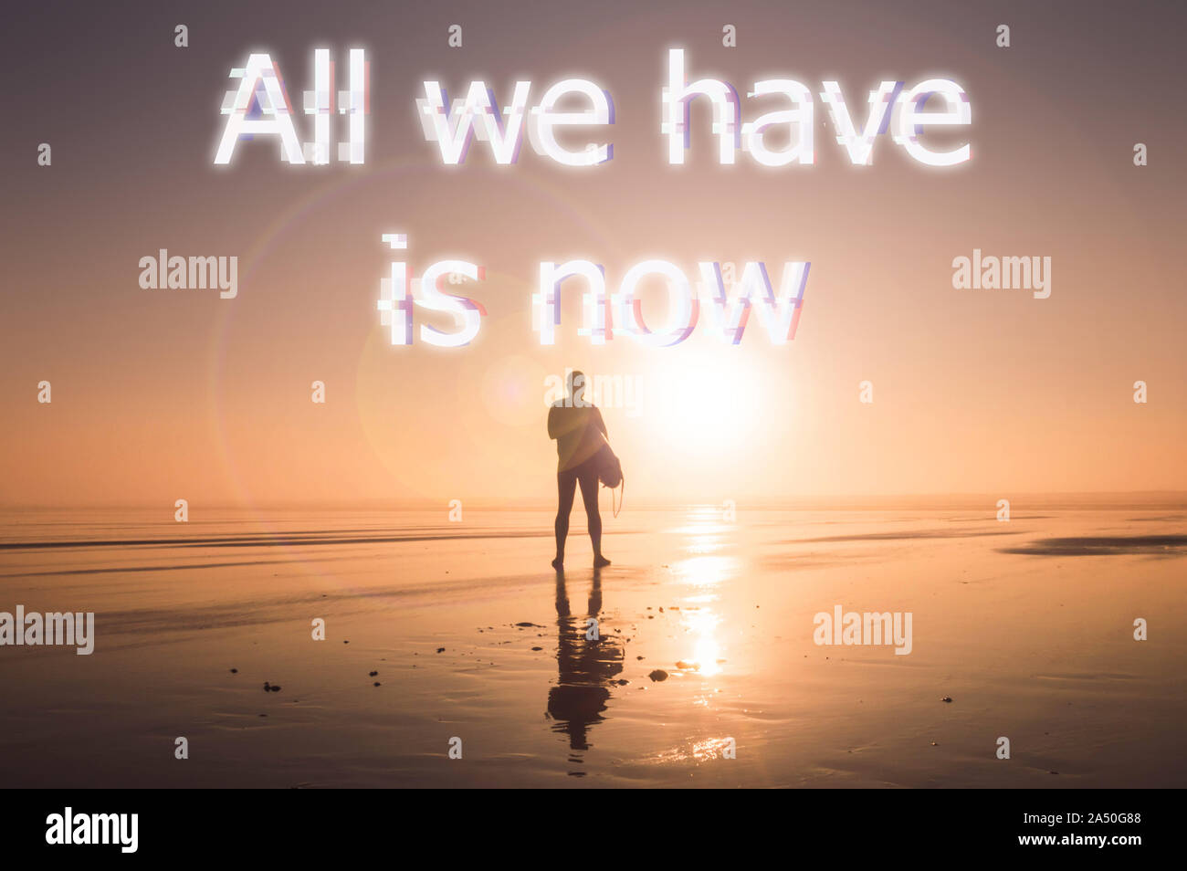A man holding a surfboard, silhouetté contre le soleil couchant, avec un effet de motivation, d'inspiration glitch mention indiquant que "Tout ce que nous avons, c'est maintenant". Banque D'Images