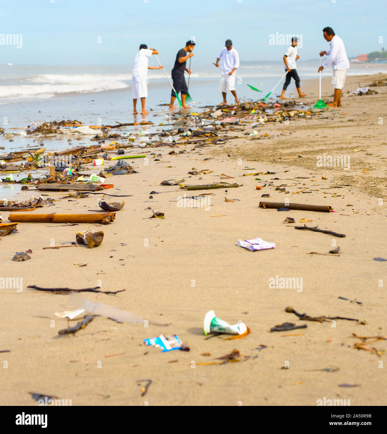 Groupe de personnes le nettoyage de la plage dans les ordures et déchets plastiques. L'île de Bali, Indonésie Banque D'Images