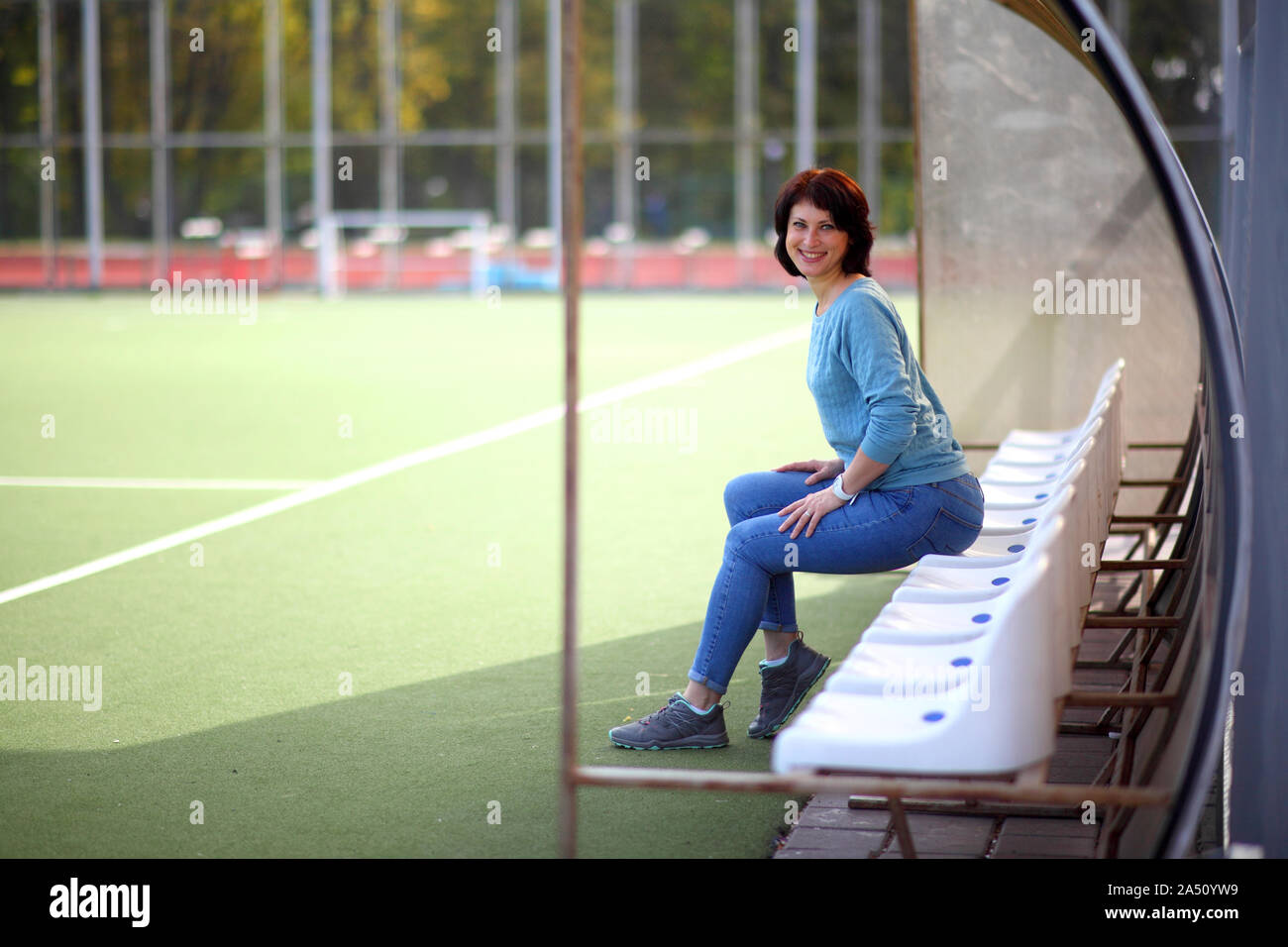 Belle femme dans le stade. Portrait d'une femme de remise en forme se reposant à stade en plein air. Banque D'Images