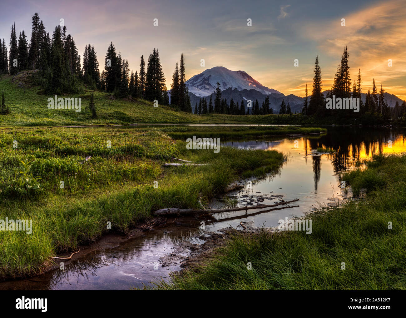 Un petit ruisseau se jette dans la région de Tipsoo Lac au coucher du soleil avec le Mont Rainier dans l'arrière-plan Banque D'Images