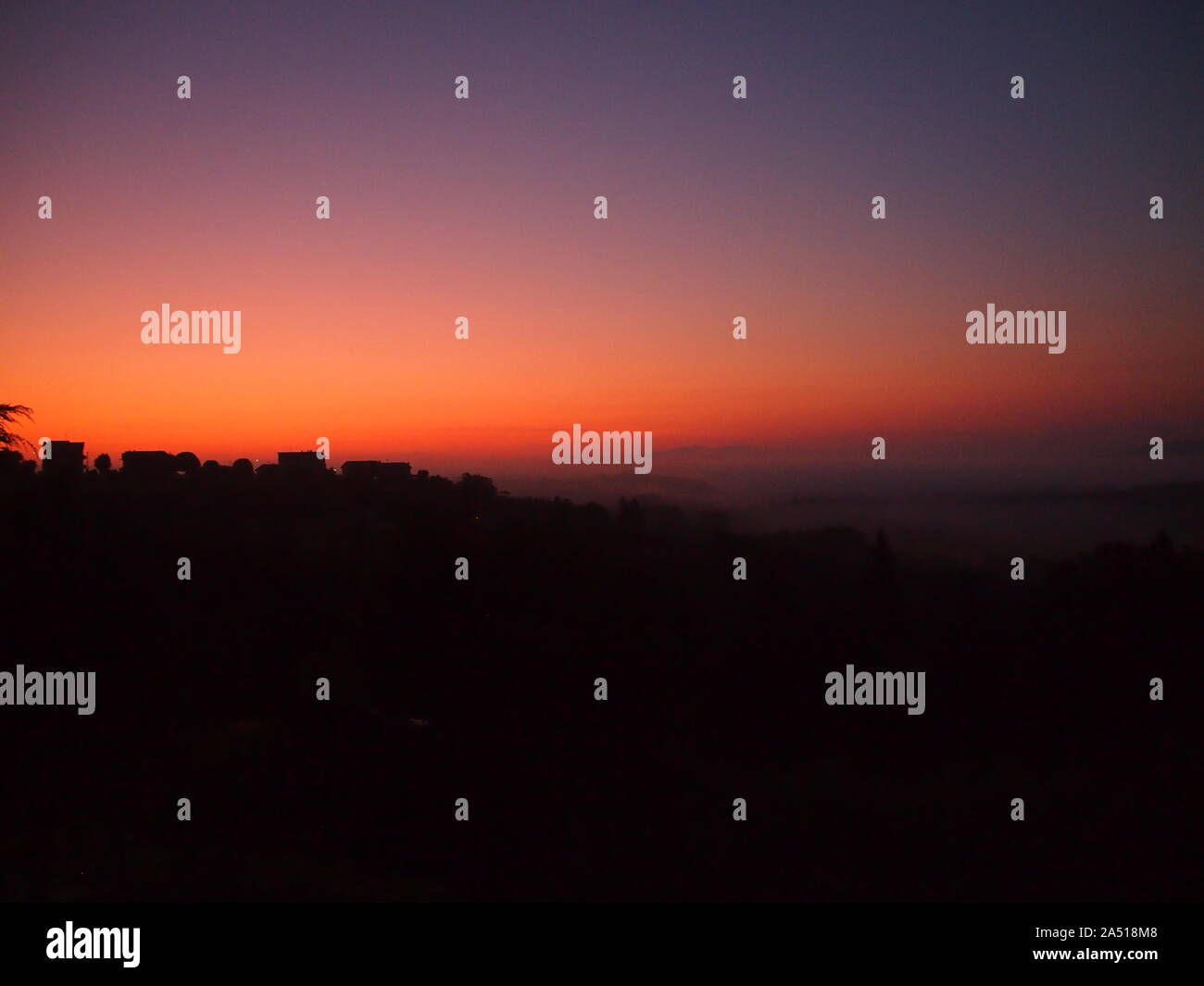 La silhouette des maisons par rose et orange sky à la première lumière de l'Ombrie, Italie Banque D'Images