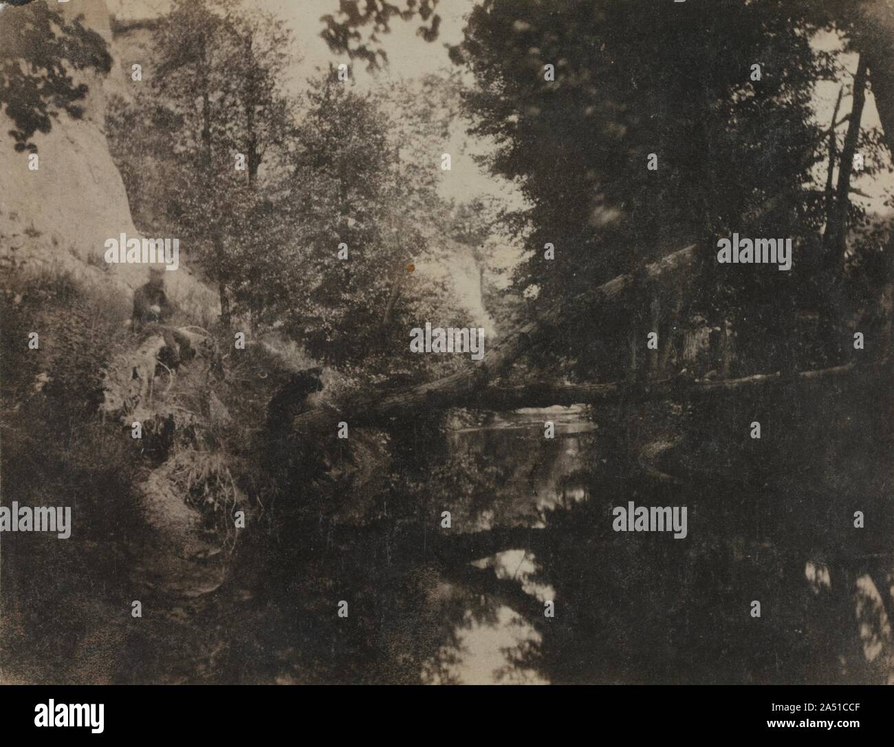 Paysage avec personnage assis sur la berge du ruisseau, ch. 1856. Inondé de lumière vive et enveloppé dans les ombres profondes, ce paysage romantique est la réalisation remarquable du début du photographe français Chauvassaignes, dont peu de renseignements biographiques sont connus. Sa maîtrise de la composition et de la technique se révèle dans ce village pittoresque de composition de l'eau, des berges, des arbres, et le feuillage, il donnait l'impression de grande tranquillité. Inspiré par les compositions de peintures et lithographies, Chauvassaignes exploité les caractéristiques inhérentes du papier négatif, lui permettant de subordina Banque D'Images