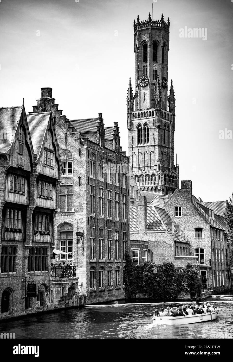 Croisière touristique en bateau à travers le canal de Dijver entouré d'une architecture médiévale avec la tour Belfort en arrière-plan, Bruges, Flandre Occidentale, Belgique Banque D'Images