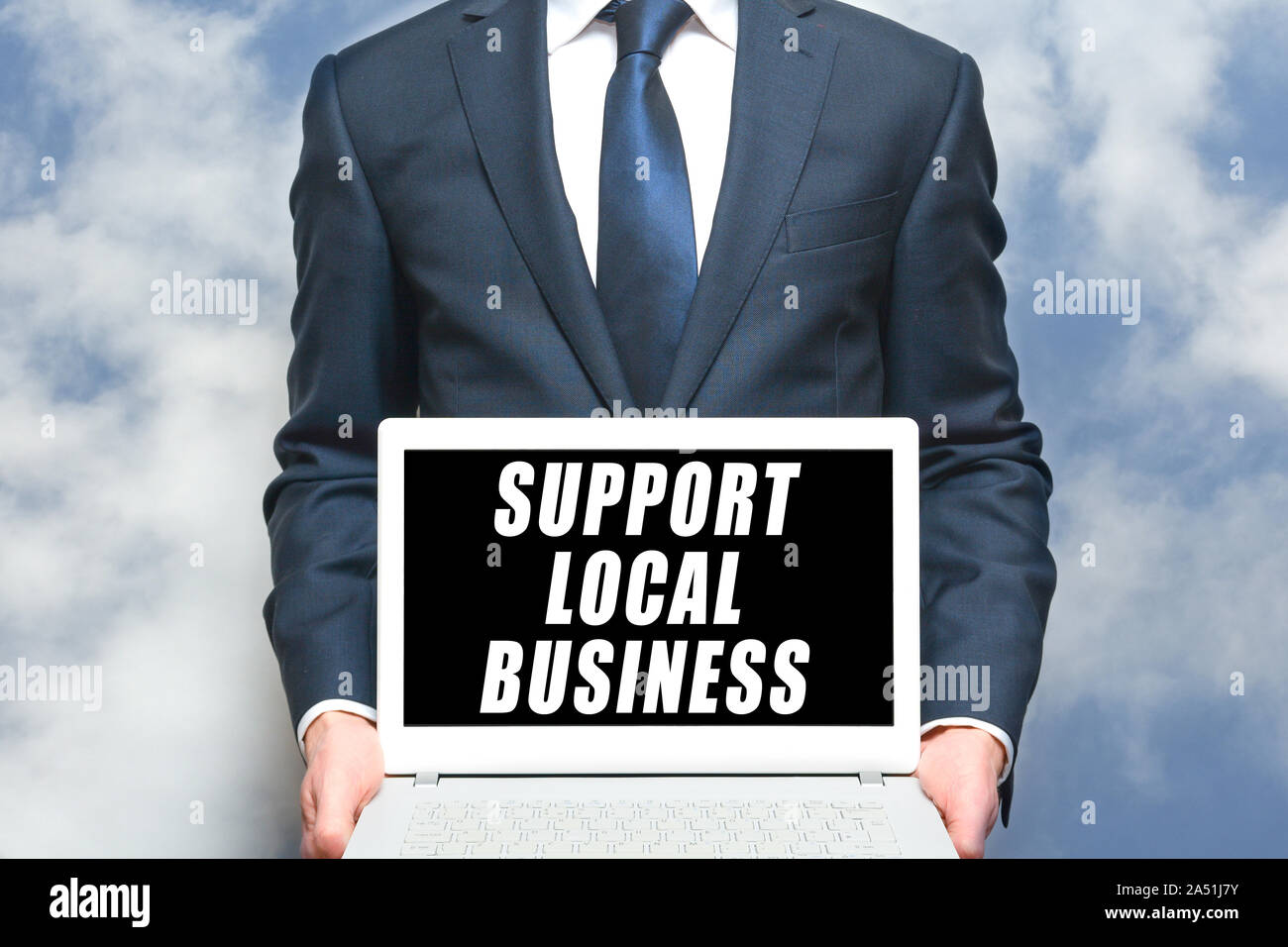 Soutien aux entreprises locales man holding sign on laptop pour promouvoir les petites entreprises locales Banque D'Images